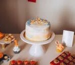 Colorful first birthday cake setup with cupcakes, perfect for celebrations and events.